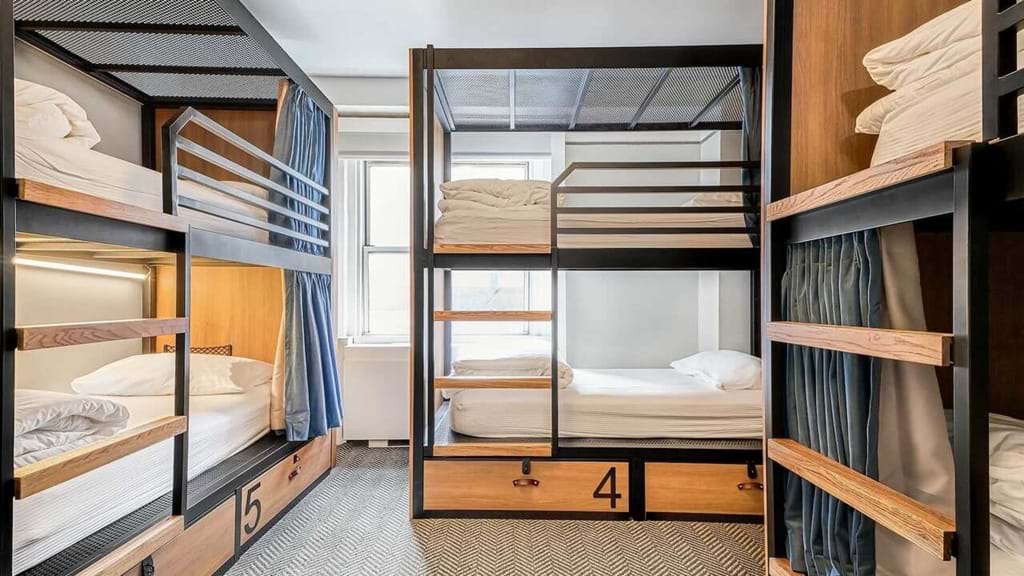 A room with multiple bunk beds and a window
